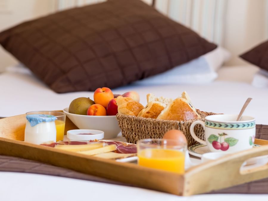 A tray with food kept on a bed at Hotel Laminak