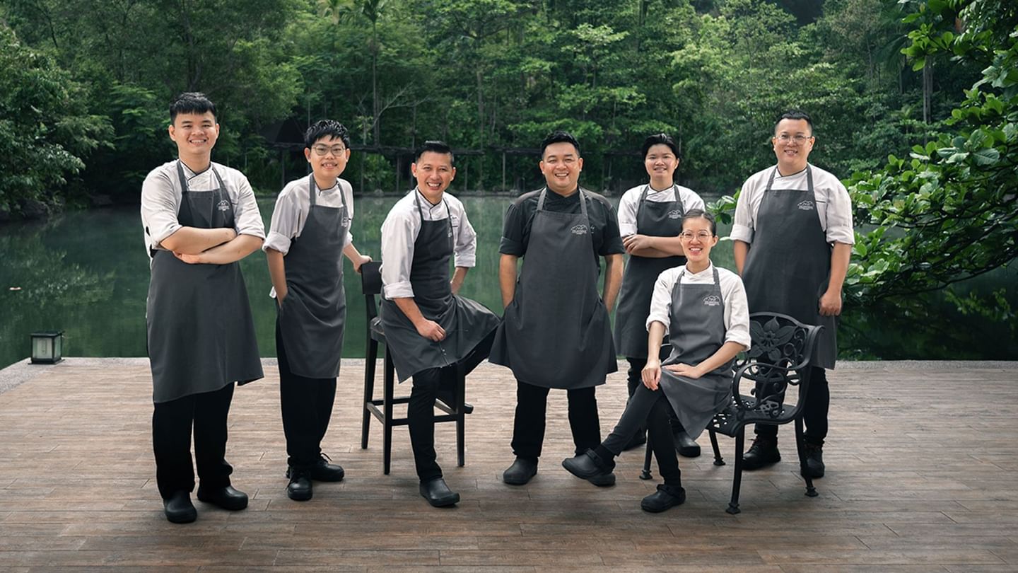 Group Jeff's Cellar Chefs posing for a picture with a lake in the background at The Banjaran Hotsprings Retreat