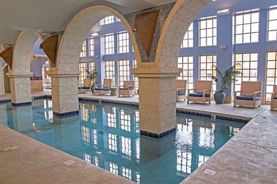 Beautiful indoor pool at Hilton Santa Fe Buffalo Thunder featuring architectural arches and large, light-filled windows