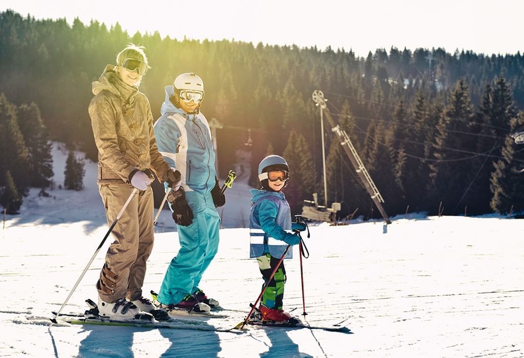 Family of three standing on skis