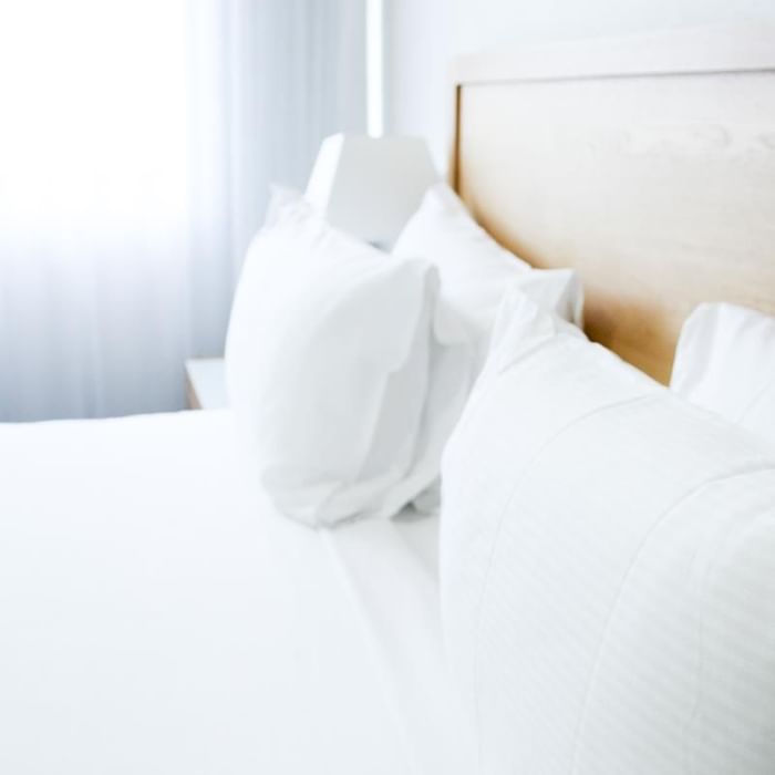 Close-up of plush white pillows arranged on the bed in a Hotel Room at Mercure Charlestown