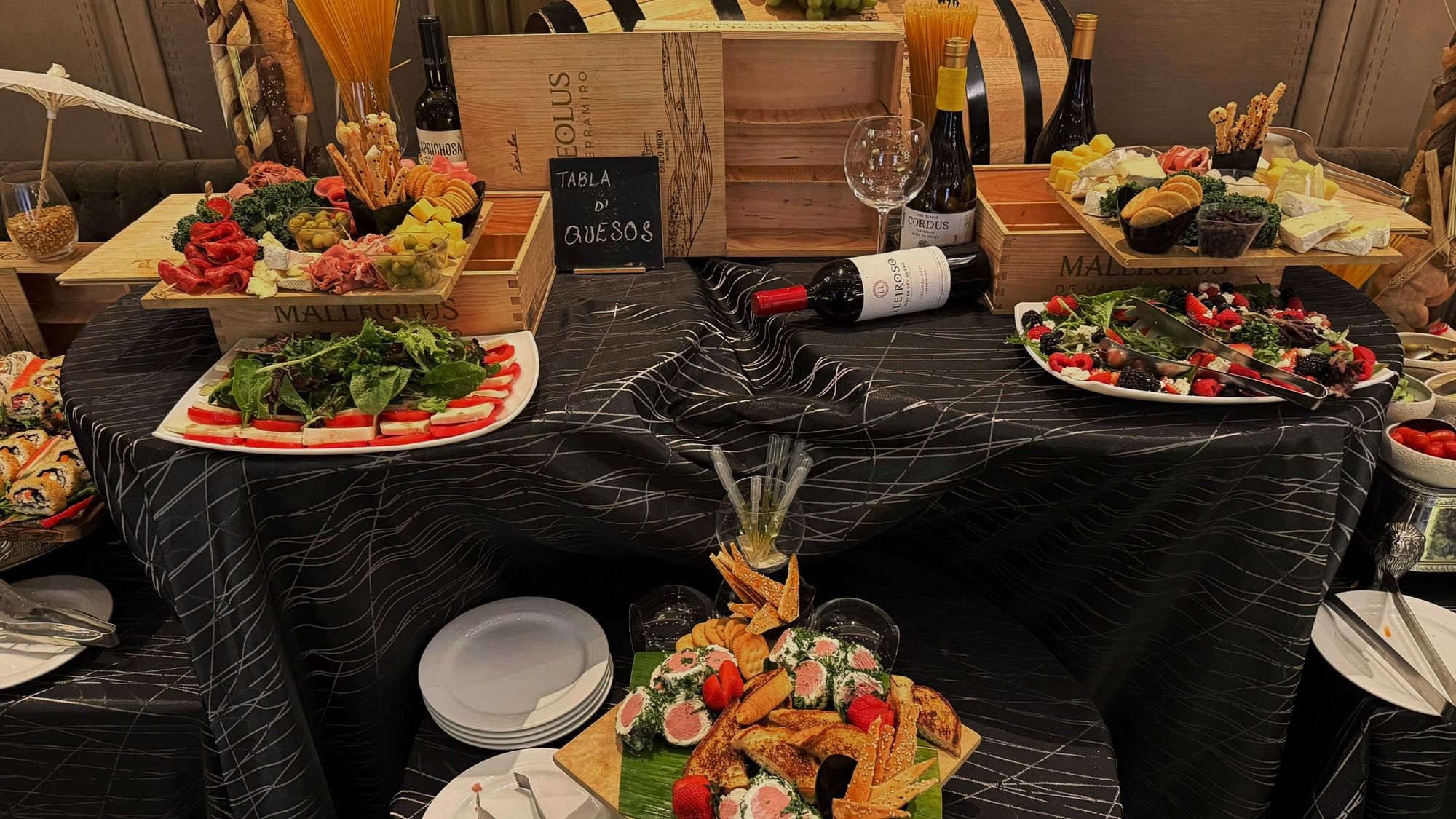 Plates of assorted appetizers and wines on a table covered with a black cloth at Quinta Real Monterrey
