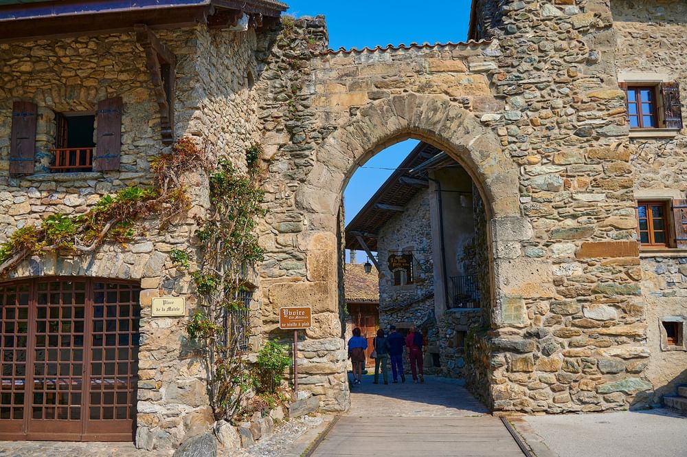 Porte de Rovorée by ivy-covered buildings under a clear blue sky near Warwick Geneva