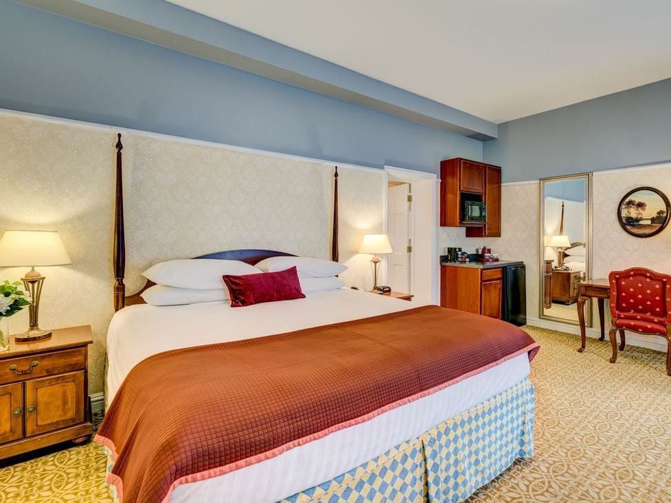 King room with one king bed, bedside lamps, and a coffee table at The Carleton of Oak Park Hotel