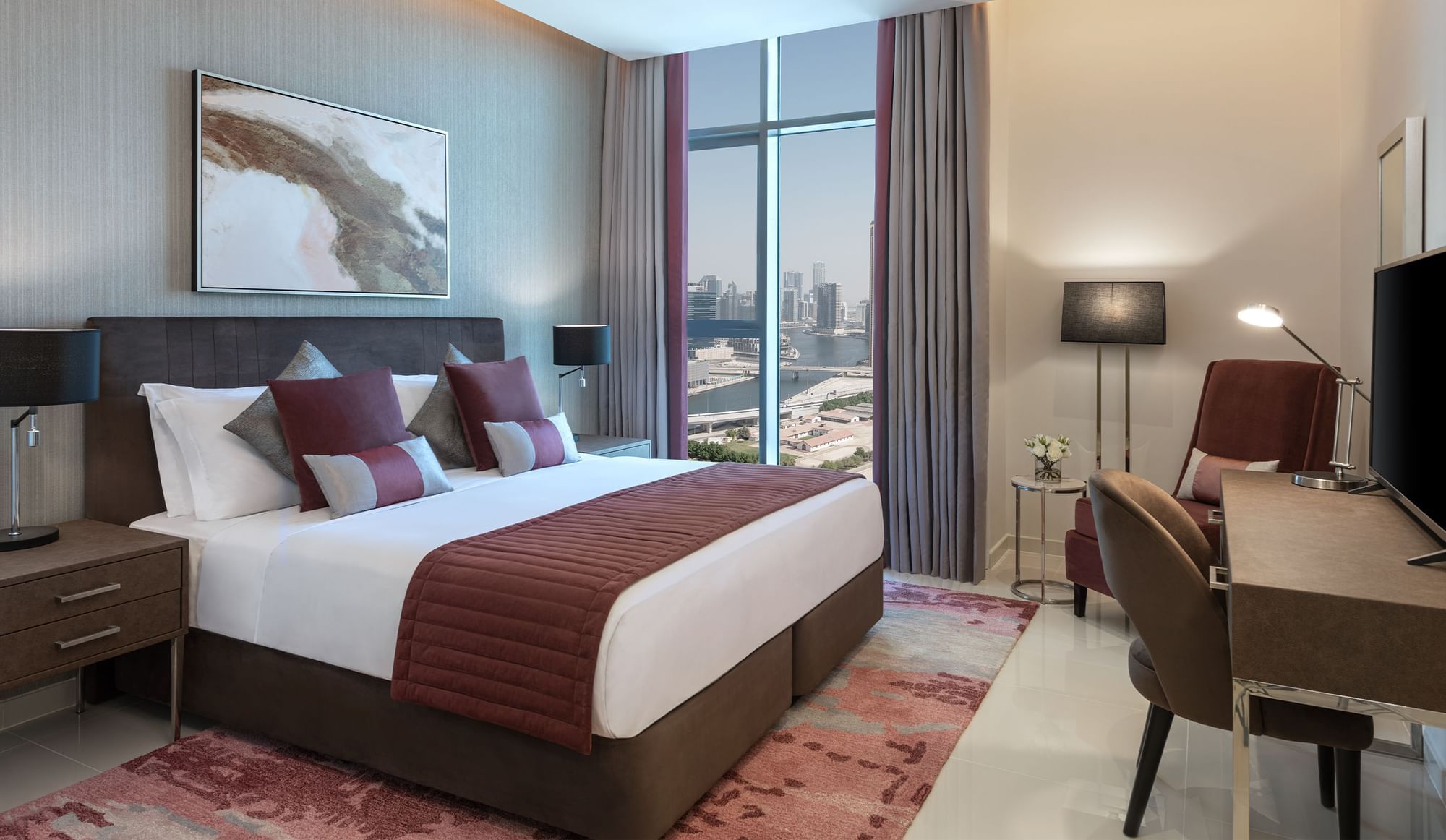 Work desk facing the cozy bed in One Bedroom with a city view at DAMAC Maison Aykon City
