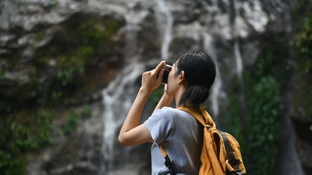 Hiker taking a photo of a waterfall