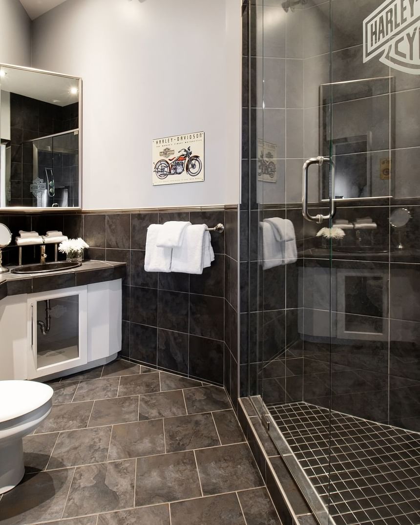 bathroom with harley davidson logo painted on dark tile in glass