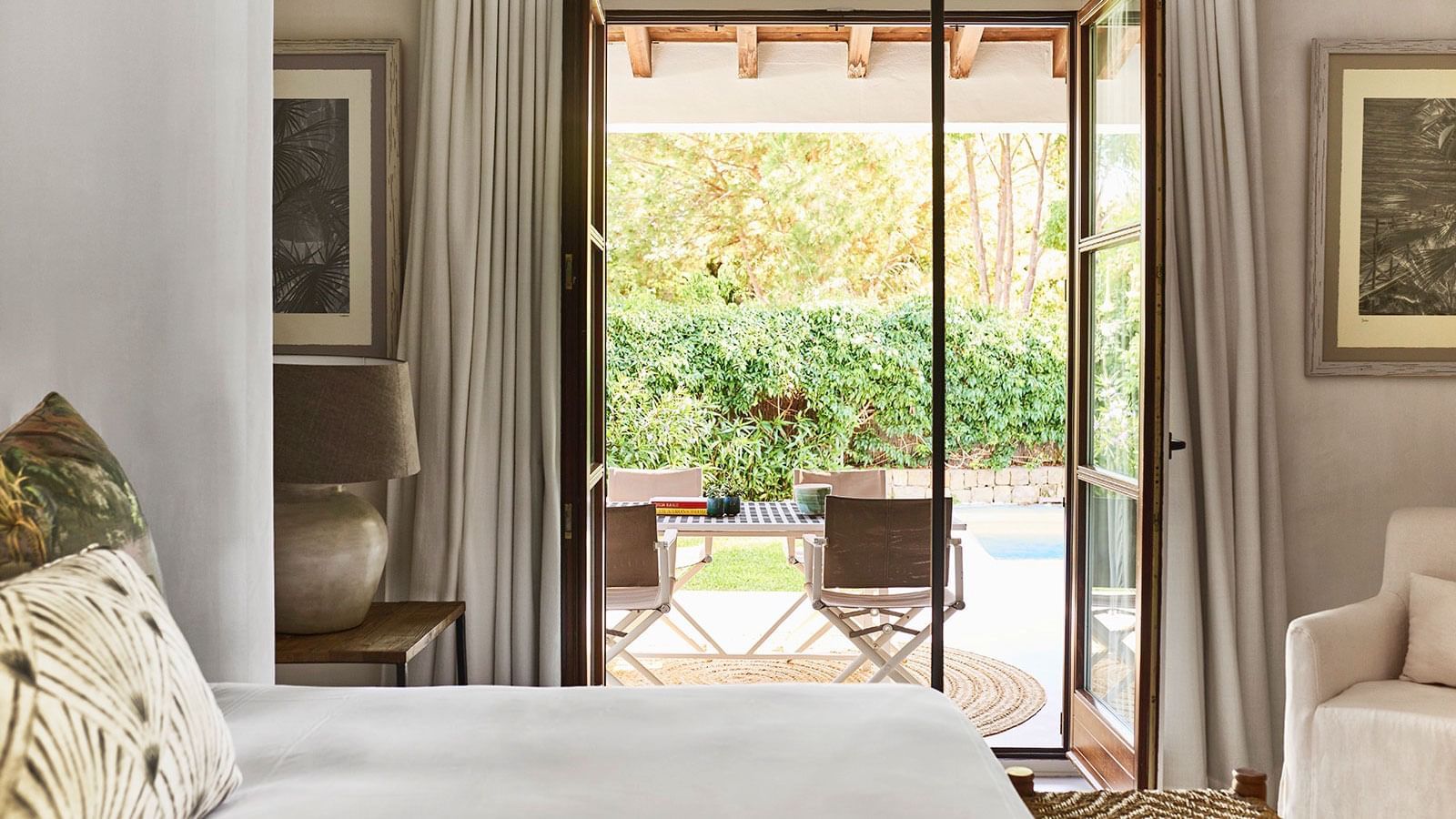 Four-Bedroom Villa looking out through open French doors to a patio with a table and chairs at Marbella Club