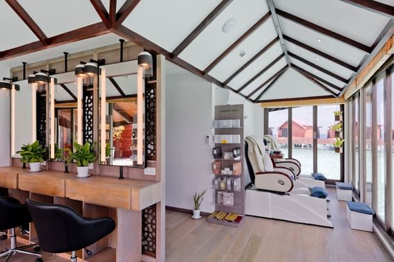 A salon interior featuring a large mirror and several stylish chairs at Grand Park Kodhipparu, Maldives