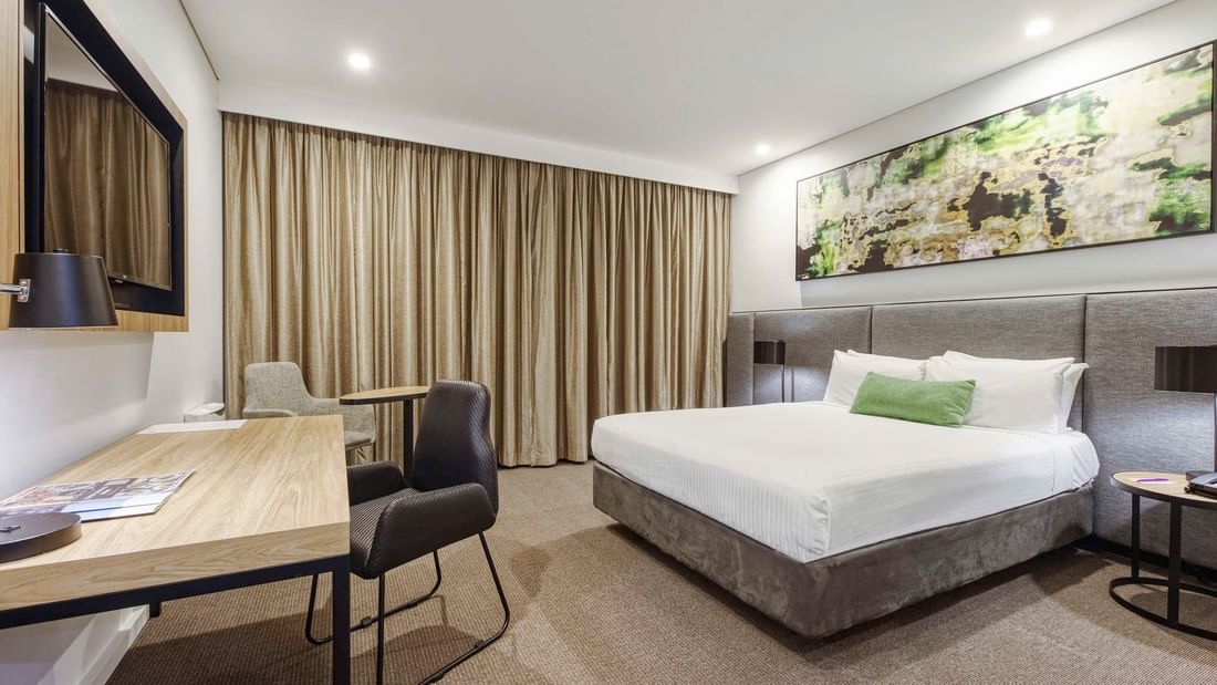 Standard Queen Room at Mercure Penrith in Penrith with bed, desk, and chairs.
