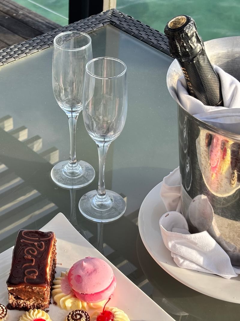 Dessert and champagne on a table at Overwater Villa at Warwick Le Lagon Vanuatu Efate.