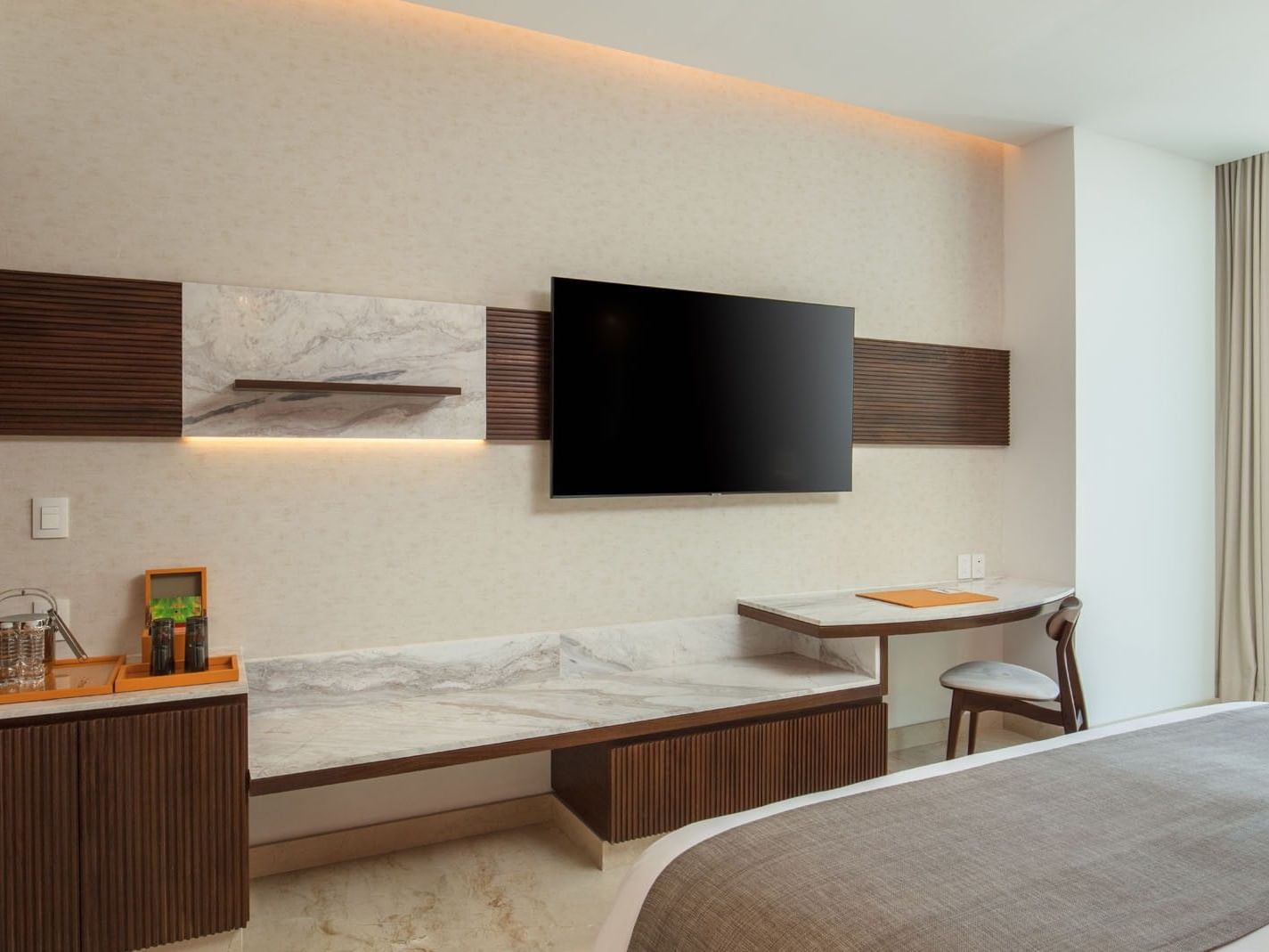 Sleek work desk and flat-screen TV setup in King Deluxe Bed perfect for the business traveler at Camino Real Merida
