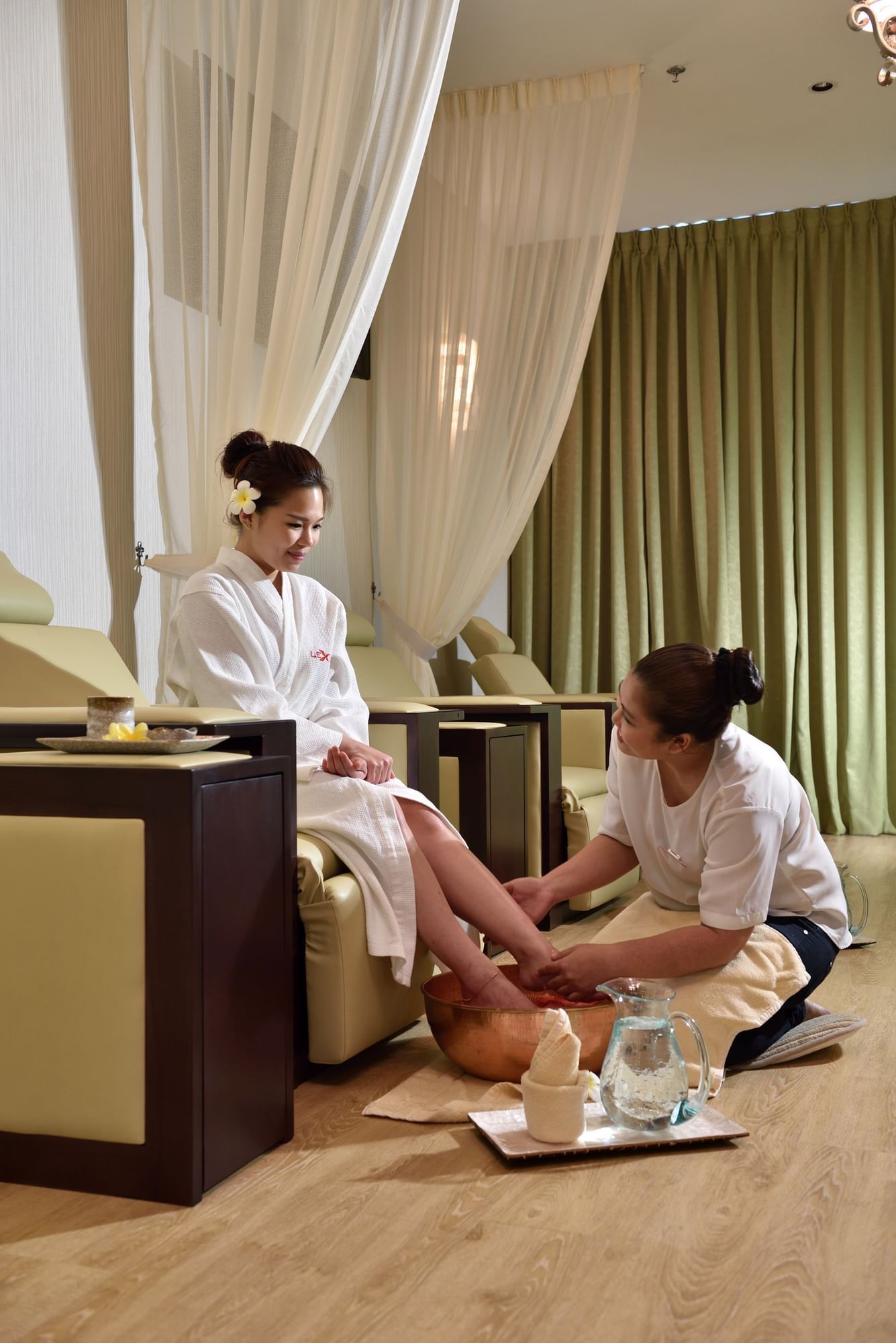 woman enjoying foot massage during a half-board vacation at Lexis Hotels and Resorts