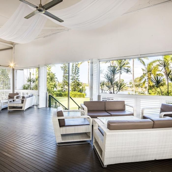 Plantation Deck with wicker furniture and large windows overlooking garden view at Mercure Hotel Townsville