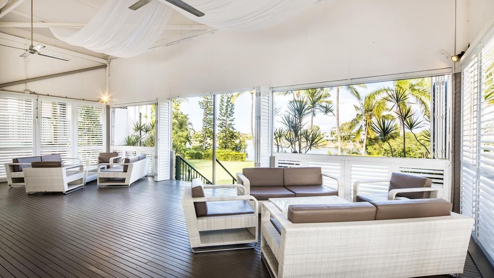 Plantation Deck with wicker furniture and large windows overlooking garden view at Mercure Hotel Townsville