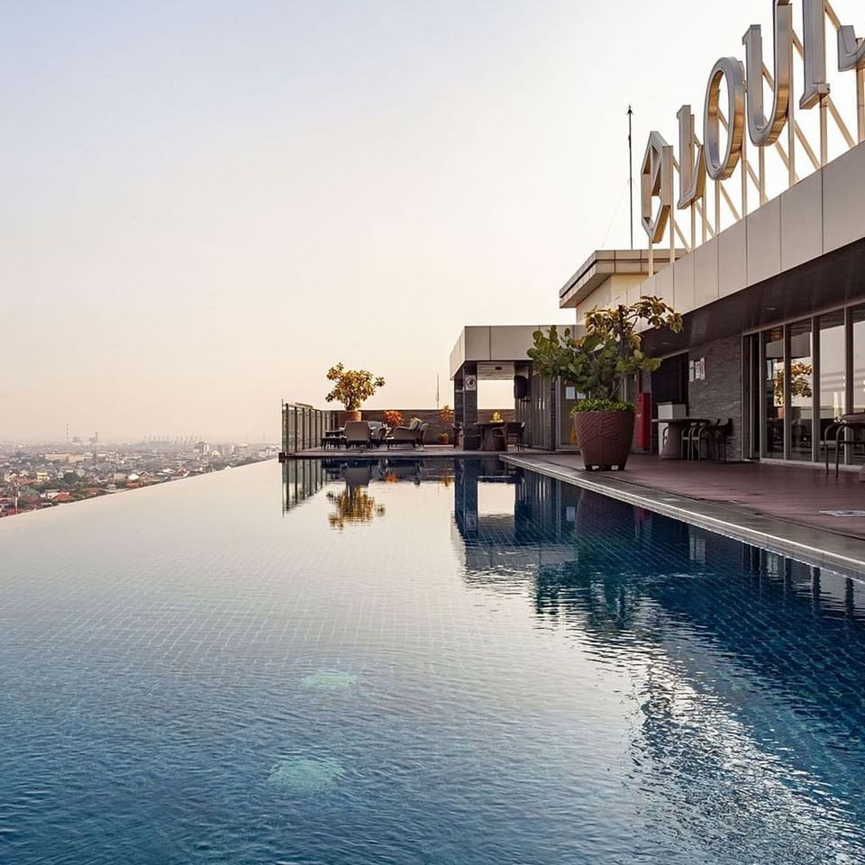 Rooftop pool area with a sign at LK Hotel Simpang Lima