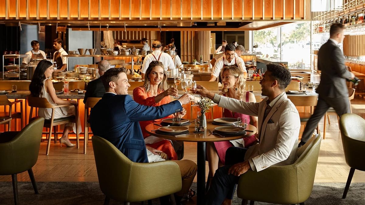Two couples toasting wine in Woodcut at Crown Towers Sydney