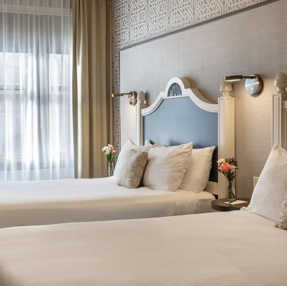 Twin Room features Two beds by a wooden desk under drum pendant lights at Warwick San Francisco