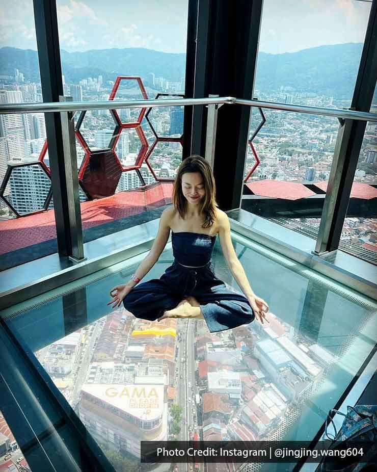 A lady was making a meditation pose at The TOP Penang Rainbow Skywalk - Lexis Suites Penang