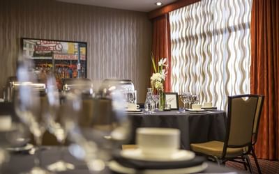 A table set for an event at The Paramount Hotel Seattle with glasses, plates, and a floral centerpiece