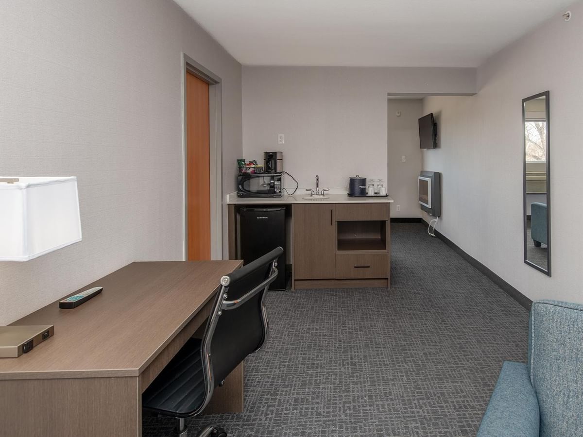 Living area of Coast Presidential Suite with desk and couch.