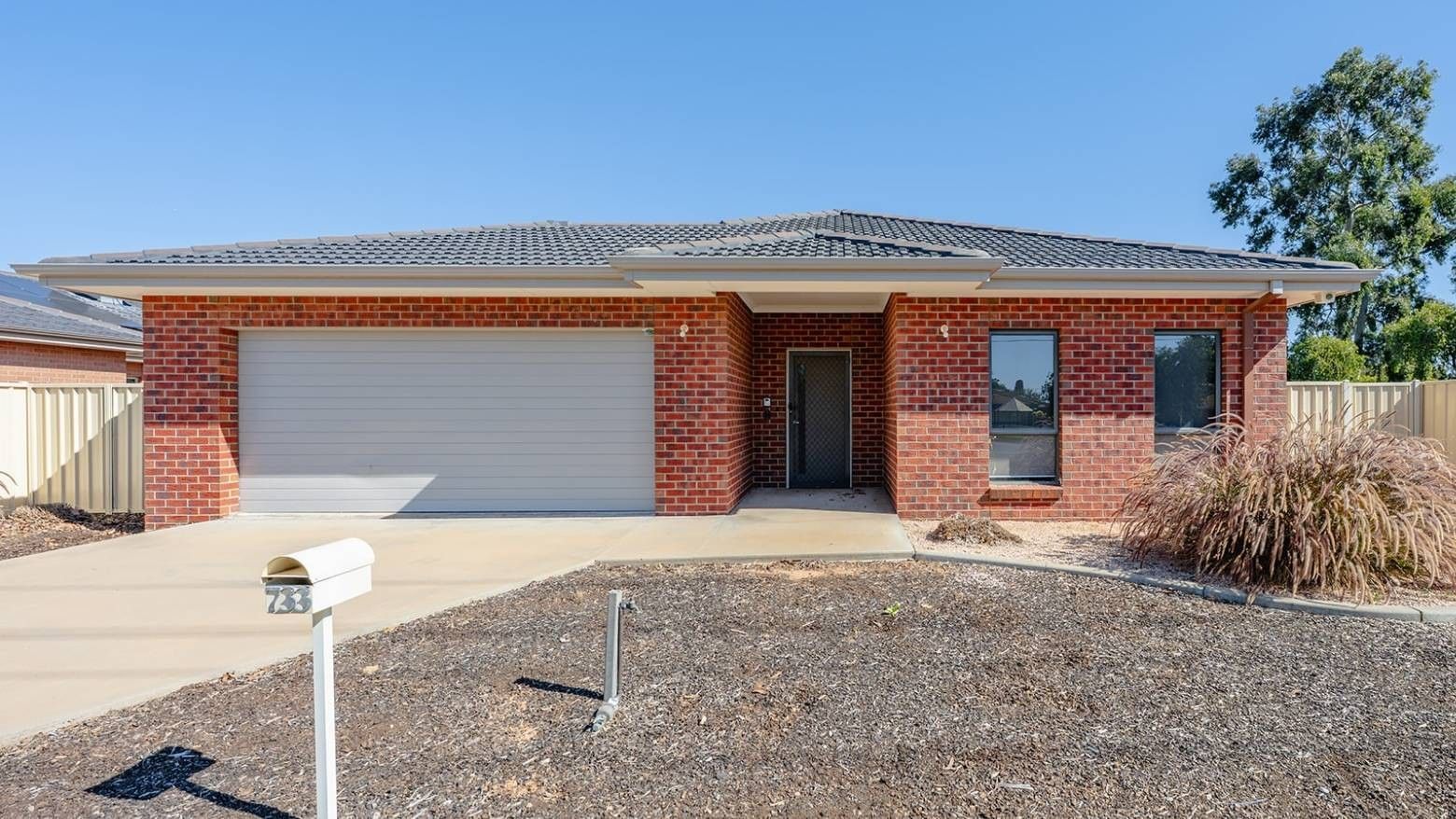 Exterior view of a brick house with garage and driveway at La Trobe University Regional Housing – Mildura.
