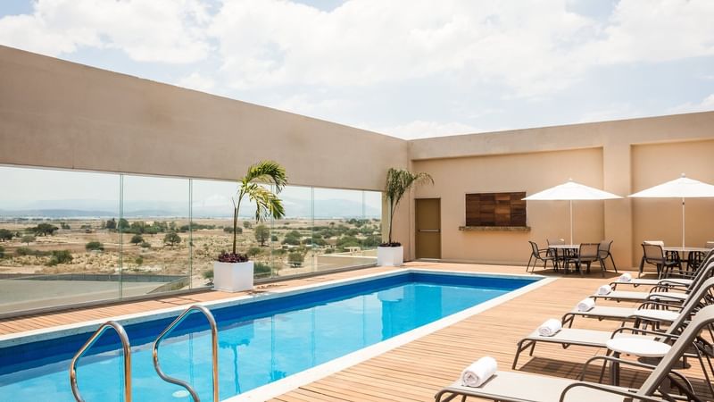 Sunbeds by the outdoor pool at Fiesta Inn Silao Puerto Interior
