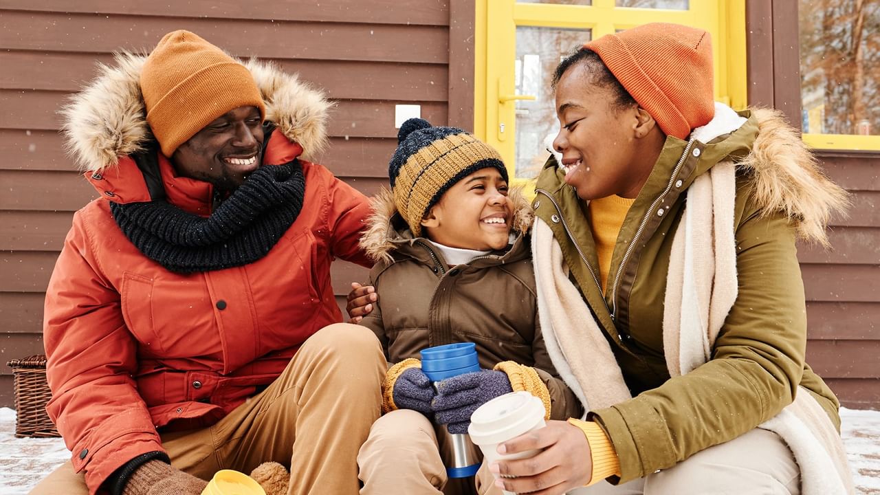 boy in winterwear sitting between parents