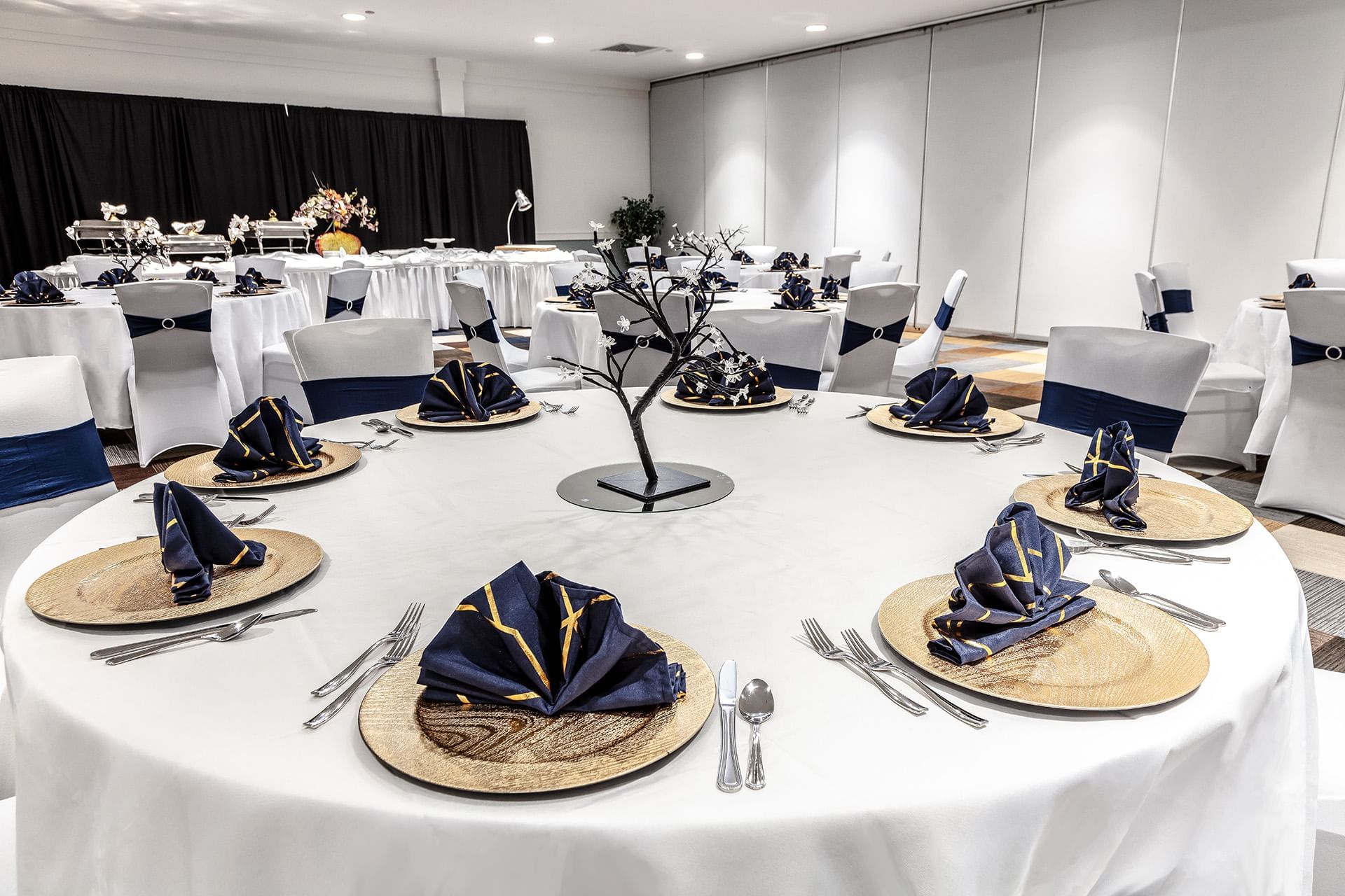 Elegant banquet with round tables, white linens, and navy napkins at The Barrymore Hotel