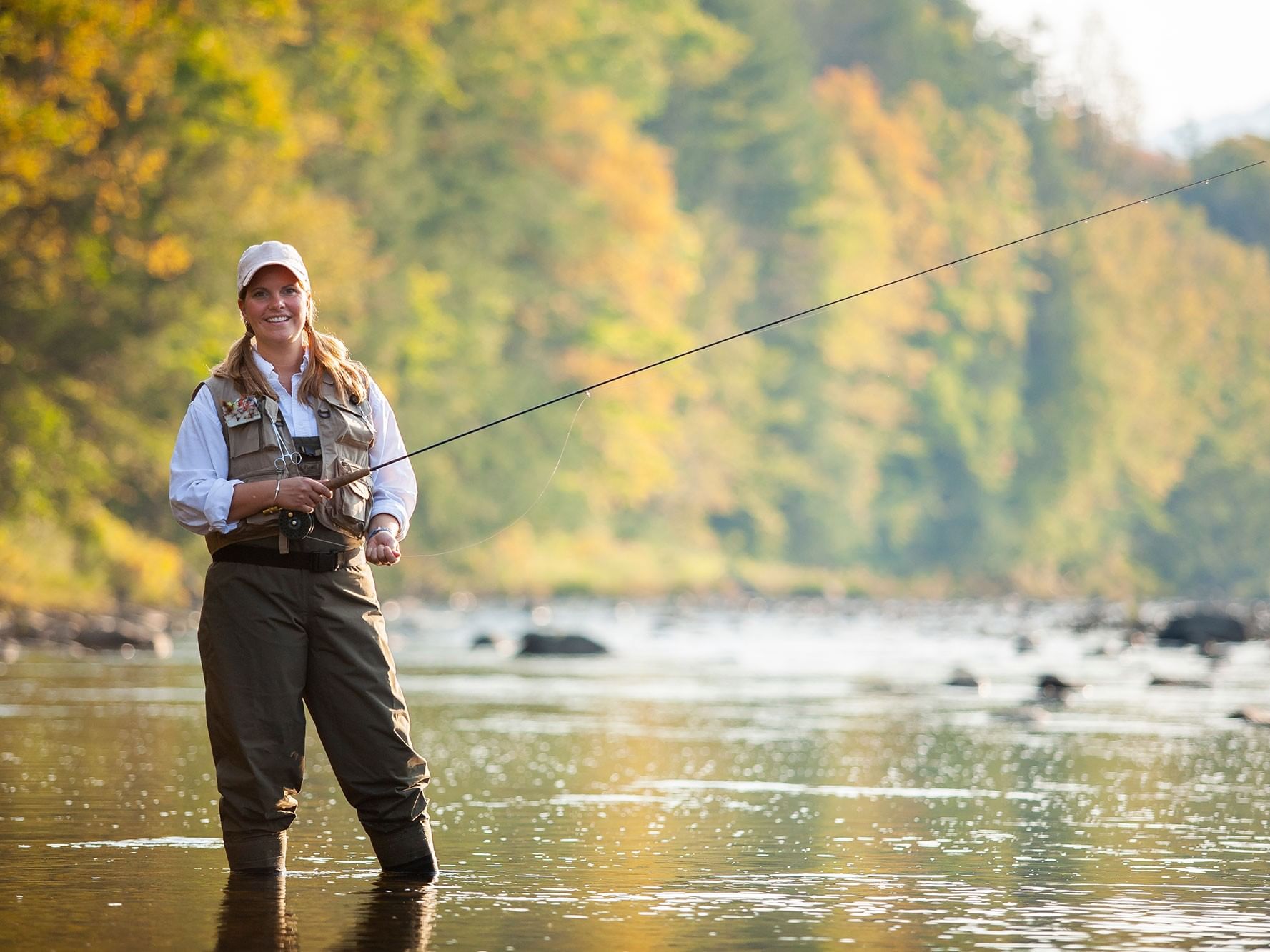 Woman fly fishing in a river in autumn as part of Reel Retreat offers.