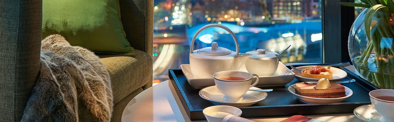 Tea set with snacks on a table in the room at Crown Tower Hotel