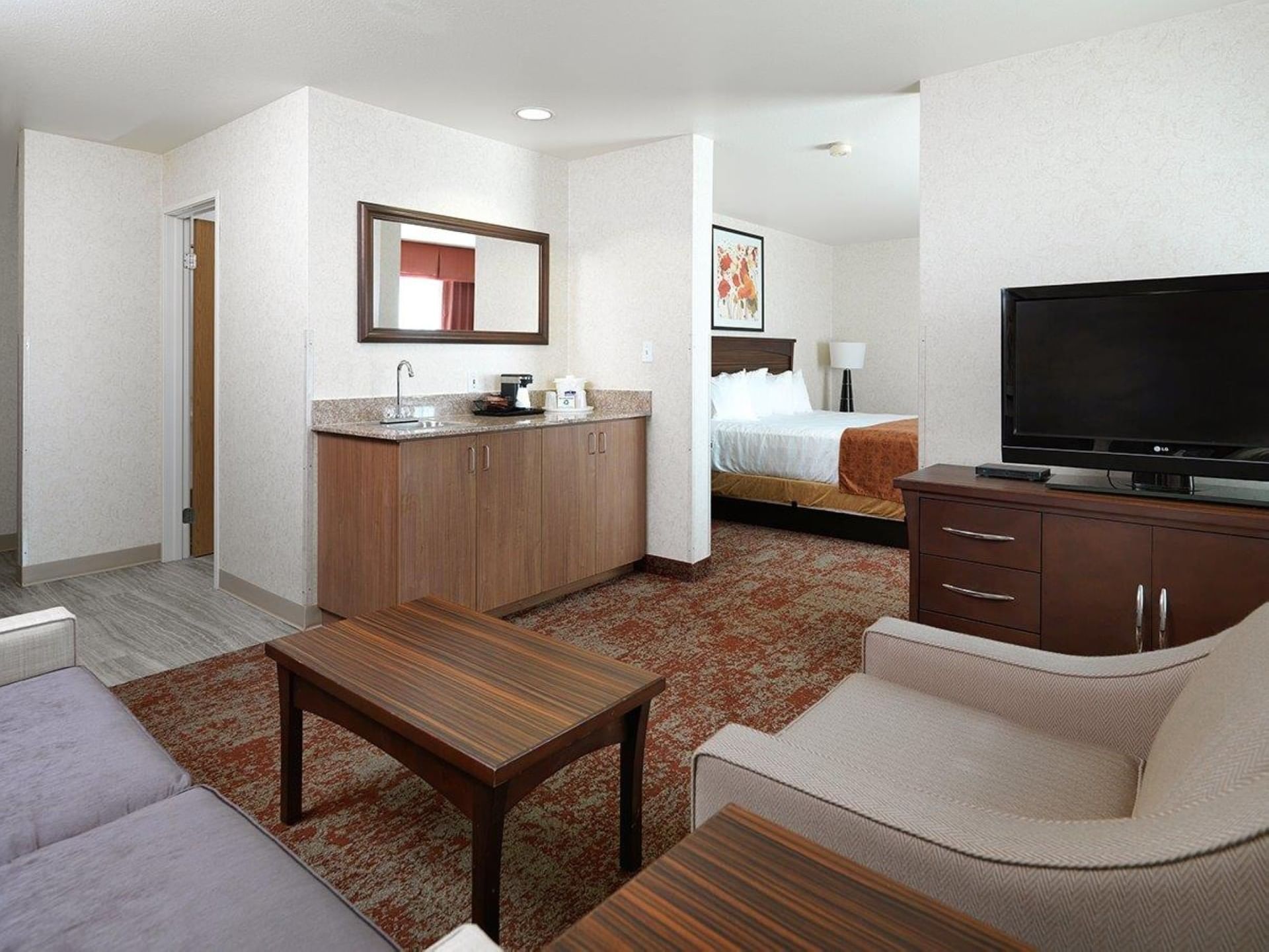 Spacious suite with dry bar, seating area, flat-screen TV, and king bed at Crystal Inn Salt Lake City