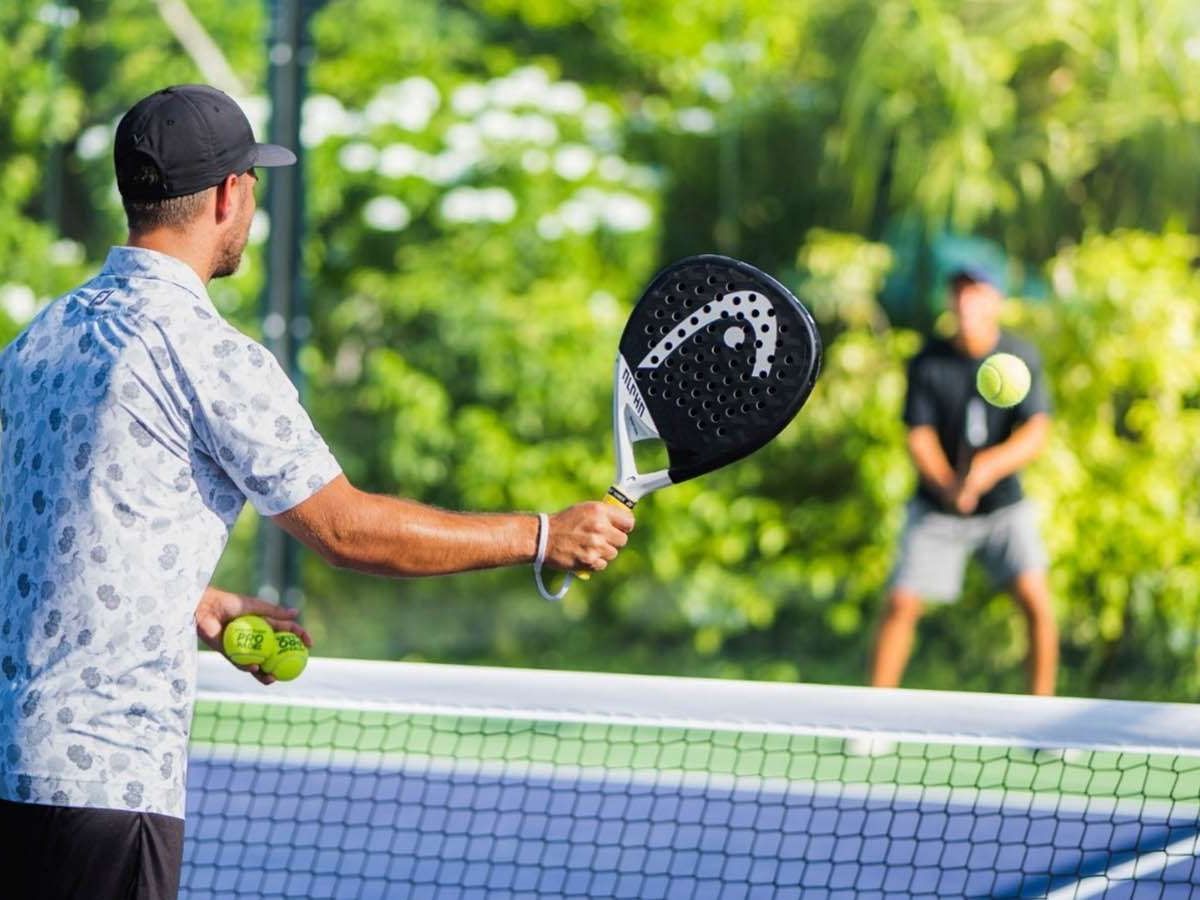 Two men playing tennis on the court at The Signature Collection