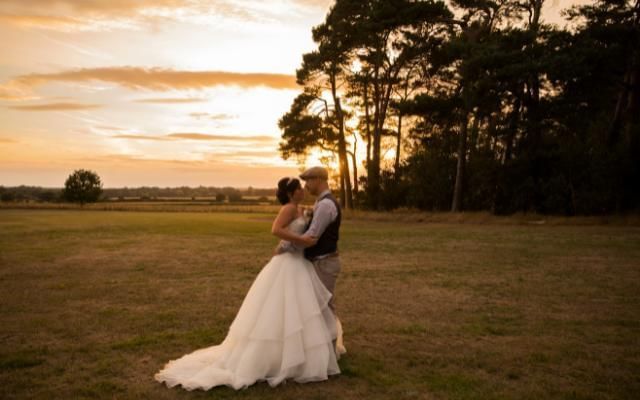 Wedding couple posing in grounds at golden hour at Easthampstead Park