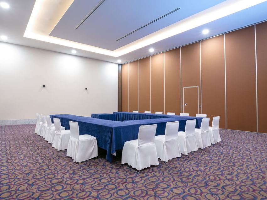Large, empty event room with a long table and chairs at Camino Real Guadalajara in Zapopan