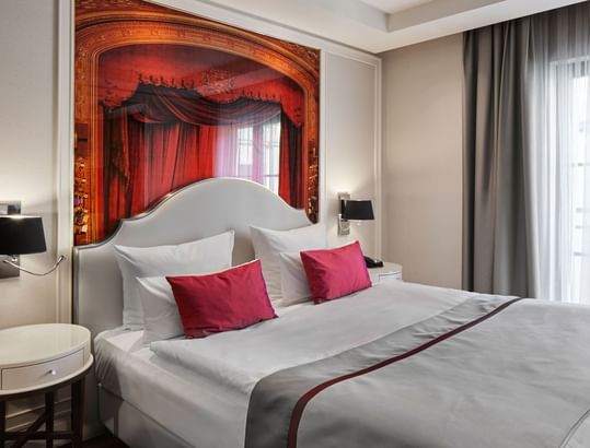 Nightstands beside the cozy bed in the Deluxe Room at Titanic Gendarmenmarkt Berlin.