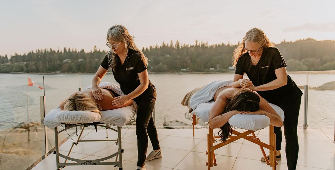 Two massage therapists giving massage