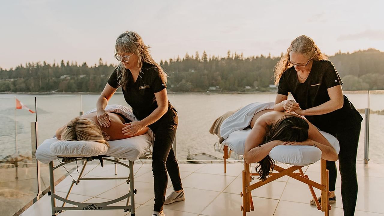 Two massage therapists giving massage