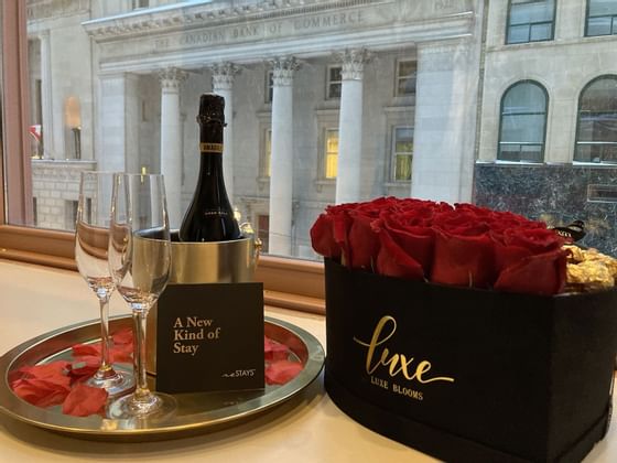 A Champagne bottle & roses by a window at ReStays Ottawa