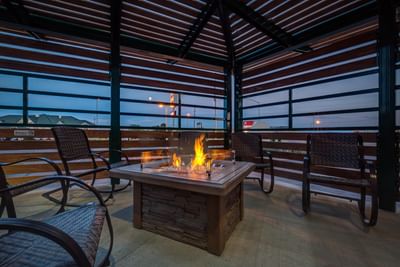 Dining & lounge area on the Patio with a firepit at night near Boothill Inn & Suites
