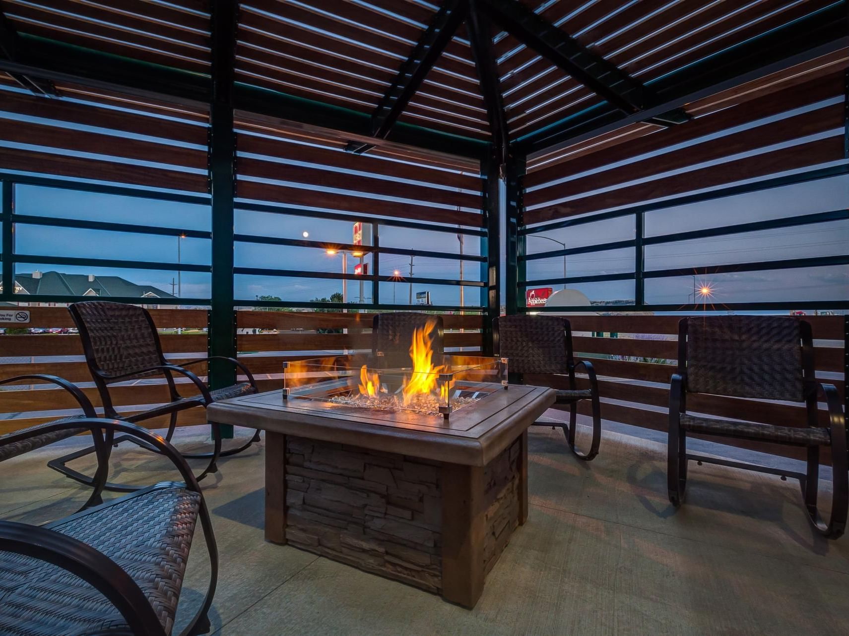 Dining & lounge area on the Patio with a firepit at night near Boothill Inn & Suites