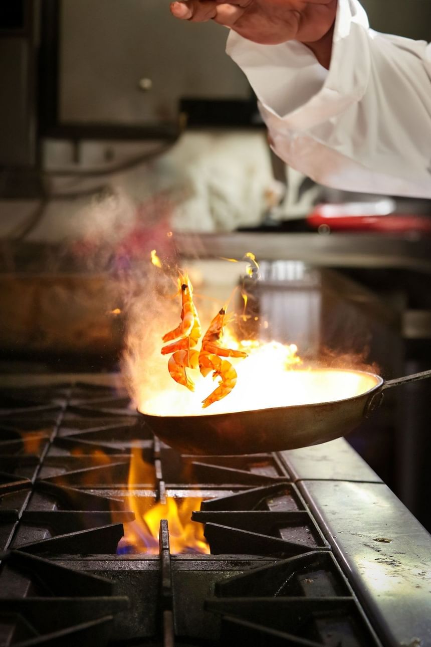 Chef tossing shrimp on the hot stove in Trade Restaurant & Lounge at Hotel Republic San Diego