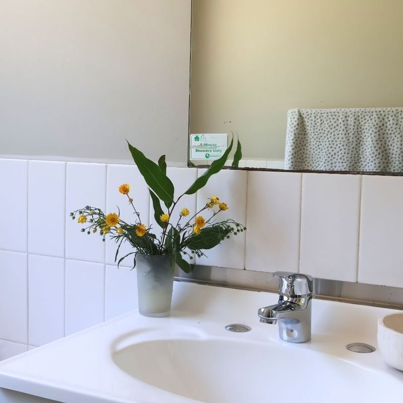 White bathroom sink with flowers and a faucet at La Trobe University - Villas.