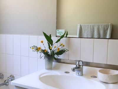 White bathroom sink with flowers and a faucet at La Trobe University - Villas.