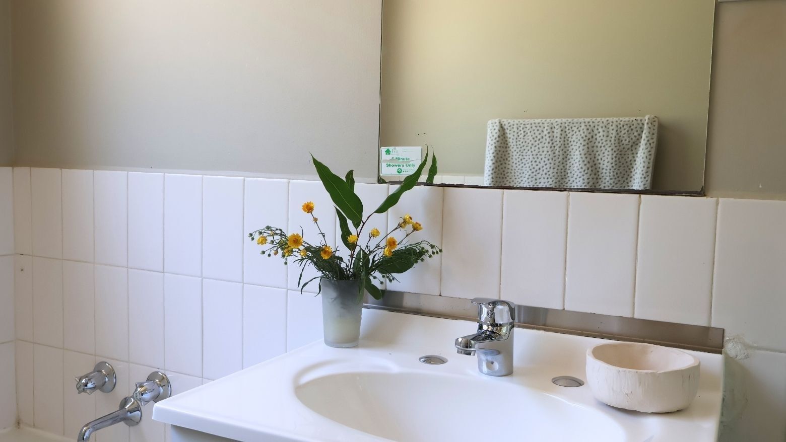 White bathroom sink with flowers and a faucet at La Trobe University - Villas.