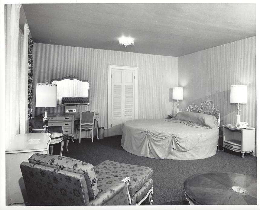 Vintage image of cozy bedroom with lounger, work desk & nightstands at Hotel Sorrento