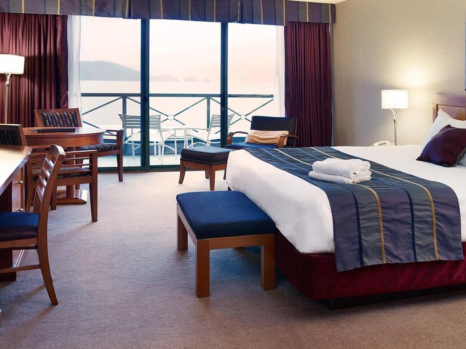 East Tower: Lake View King with cozy bed and working area at Harrison Hot Springs Resort