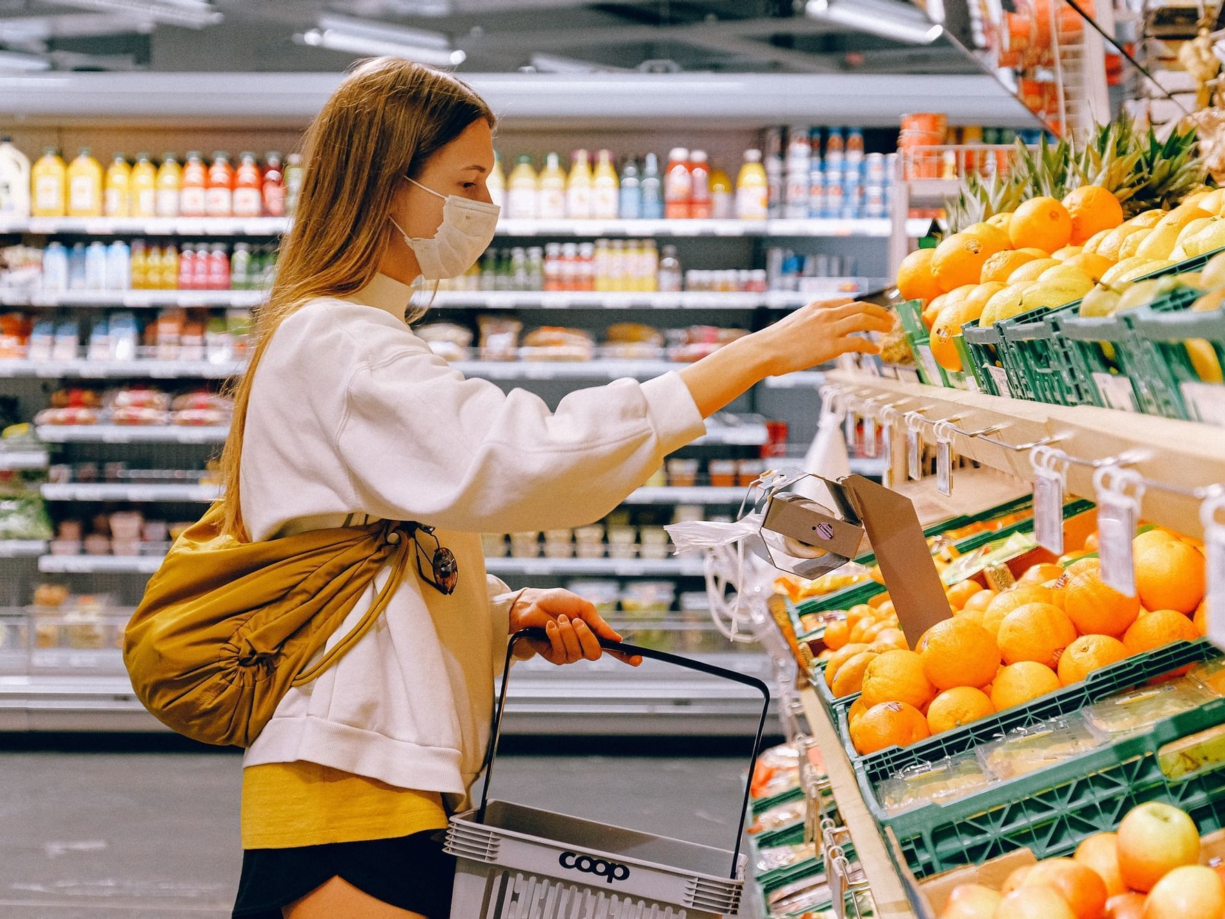 A lady selecting oranges in supermarket near Nesuto St Martins