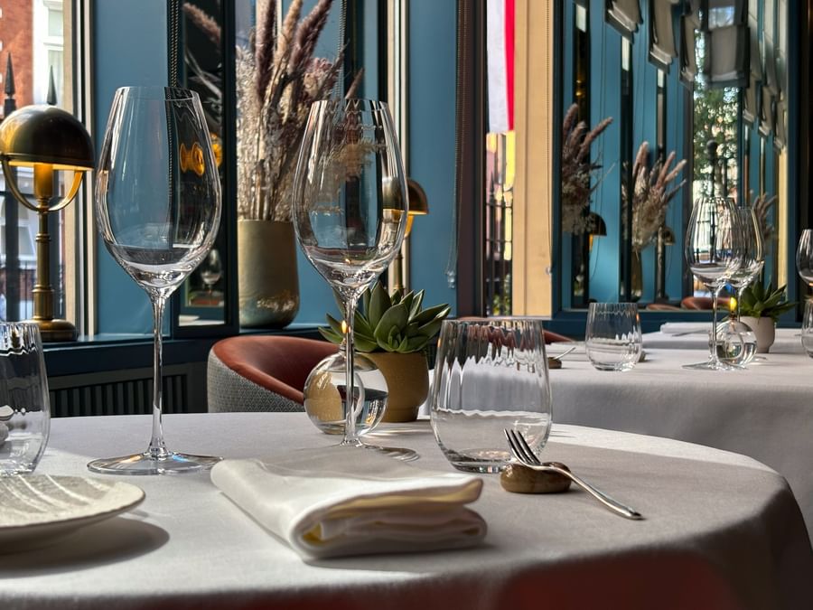 Fine dining table set by blue walls and brass lamps at The Capital Hotel, Apartments and Townhouse