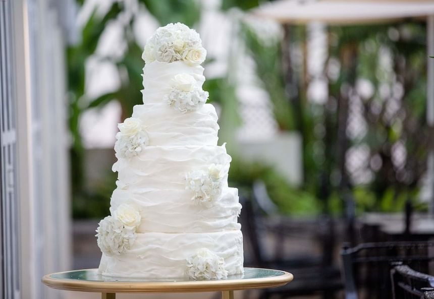 Tiered white wedding cake with textured icing and white floral decorations at Park Hyatt Saigon